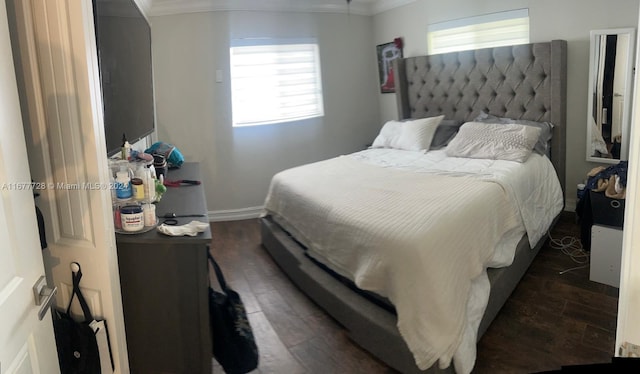 bedroom with multiple windows, dark hardwood / wood-style floors, and crown molding