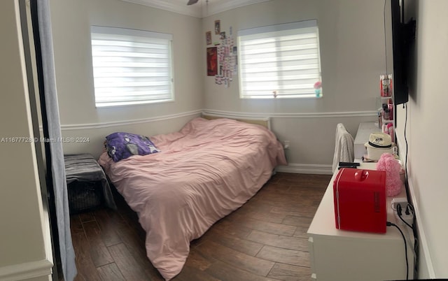 bedroom with dark wood-type flooring, crown molding, and multiple windows