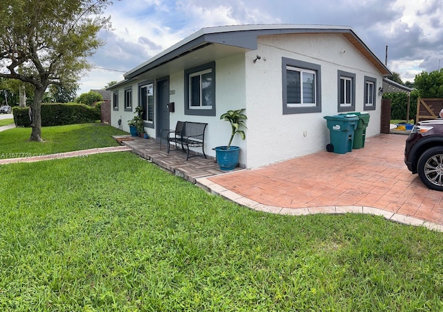 view of property exterior featuring a patio area and a lawn