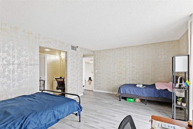 bedroom featuring a textured ceiling and light wood-type flooring