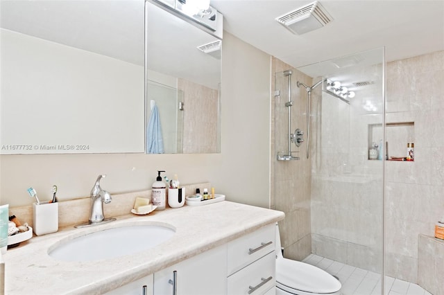 bathroom featuring a shower with door, vanity, and toilet