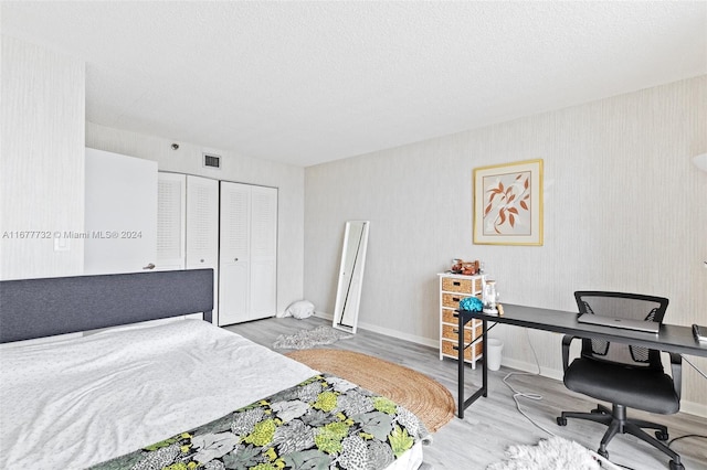 bedroom featuring hardwood / wood-style floors, a textured ceiling, and a closet