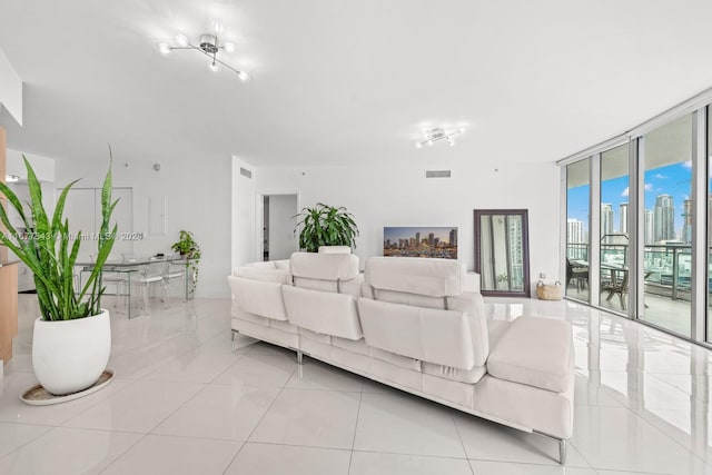 living room with a wall of windows and light tile patterned floors