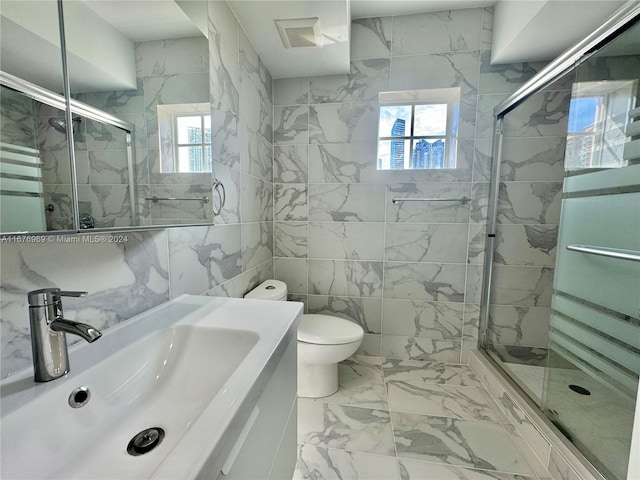 bathroom featuring vanity, toilet, tile walls, and a shower with shower door