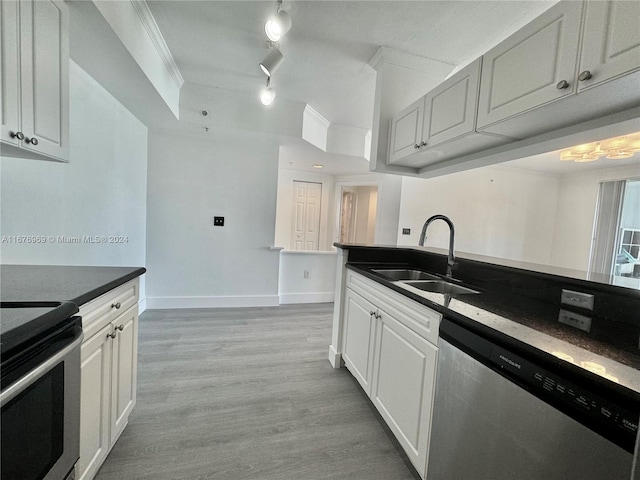 kitchen featuring white cabinets, ornamental molding, sink, light hardwood / wood-style floors, and stainless steel appliances