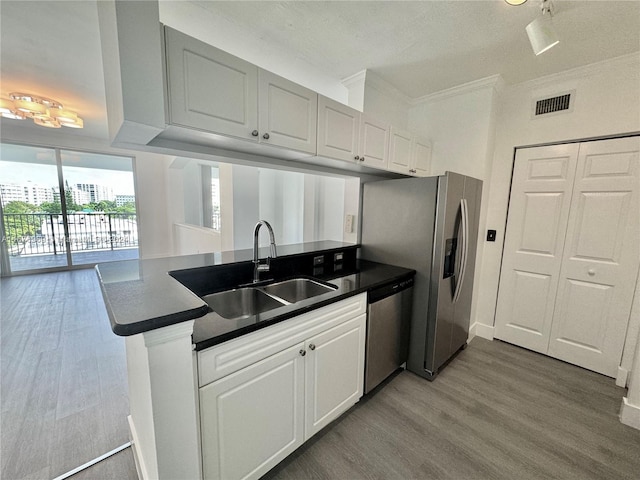 kitchen featuring white cabinets, stainless steel appliances, sink, and light wood-type flooring