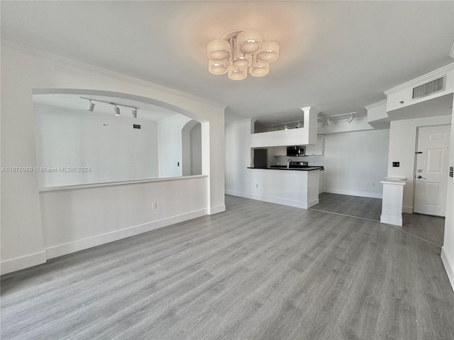 unfurnished living room featuring rail lighting, ornamental molding, sink, and light wood-type flooring