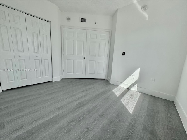 unfurnished bedroom with light hardwood / wood-style flooring and a textured ceiling