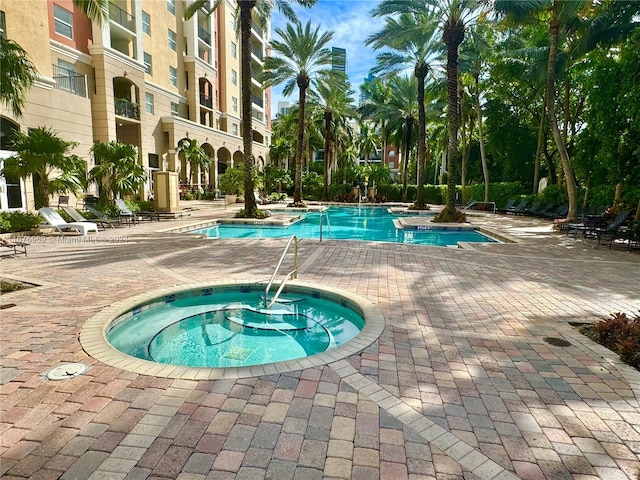 view of swimming pool featuring a community hot tub and a patio