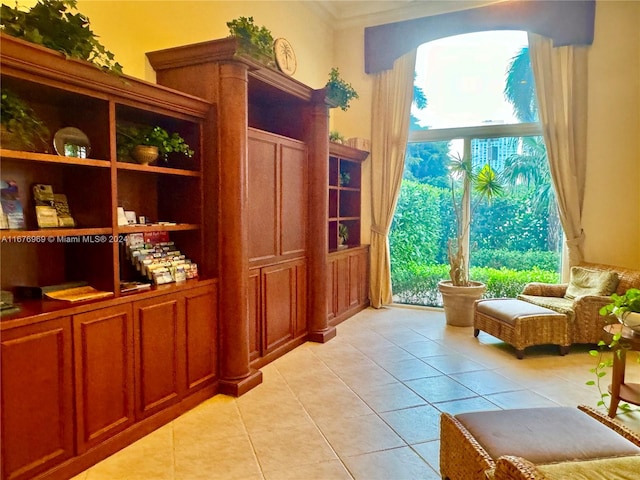 living area featuring ornamental molding and light tile patterned floors