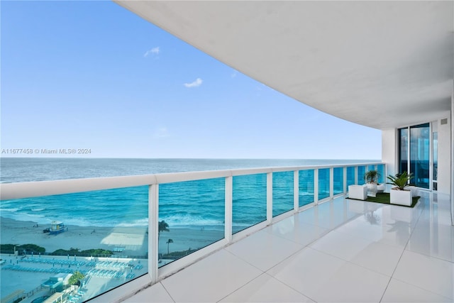 balcony with a water view and a view of the beach