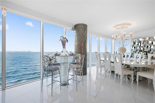 tiled dining area featuring an inviting chandelier and a water view