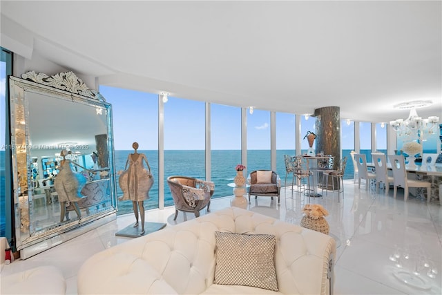 living room with floor to ceiling windows, a water view, and a chandelier