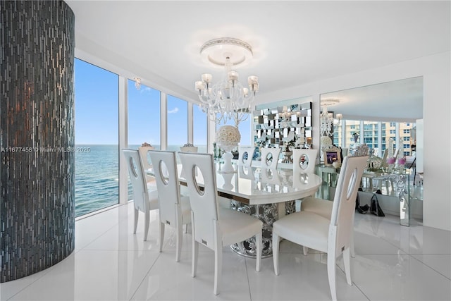 dining space with a chandelier, tile patterned flooring, and a water view