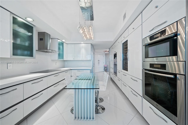 kitchen featuring modern cabinets, double oven, wall chimney exhaust hood, white cabinets, and black electric stovetop