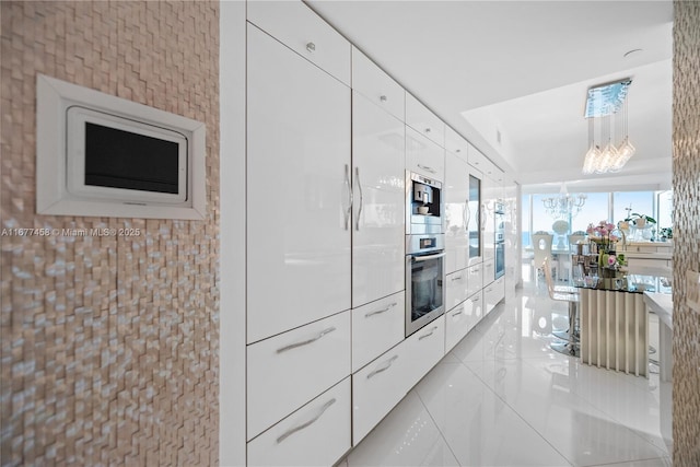 kitchen featuring marble finish floor, white cabinetry, and modern cabinets