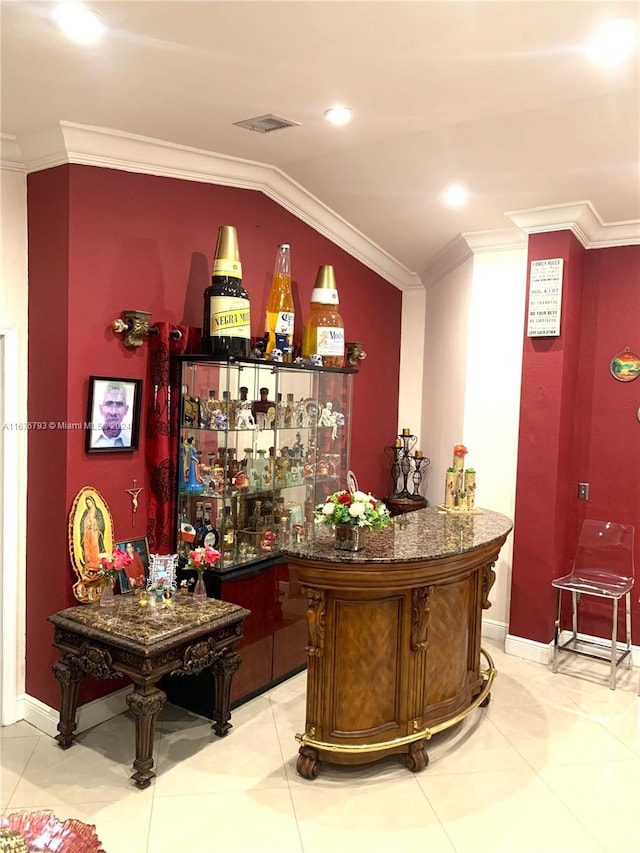 bar with light tile patterned flooring, vaulted ceiling, and ornamental molding