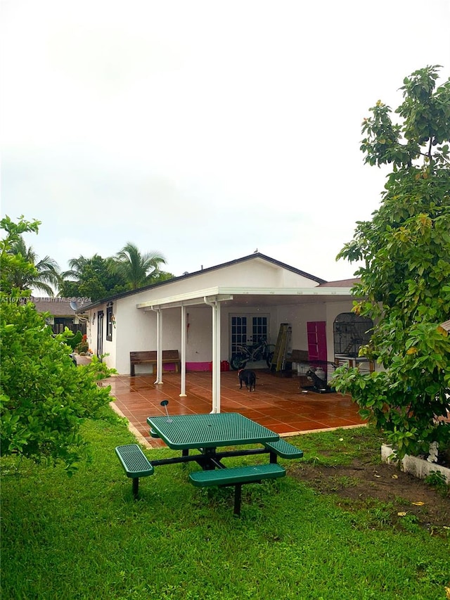 back of house with a yard and a patio