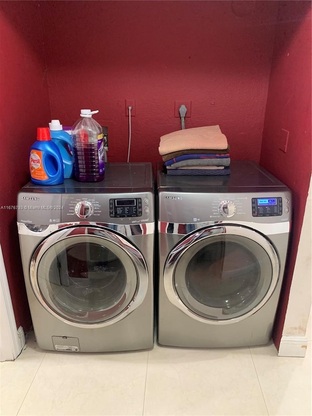 laundry area with washer and clothes dryer and tile patterned flooring