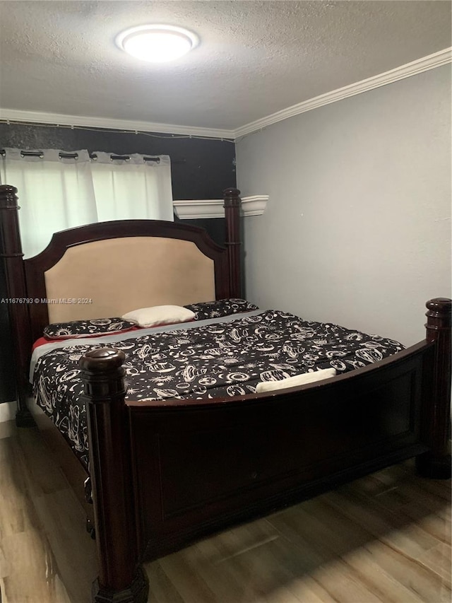 bedroom with crown molding, a textured ceiling, and hardwood / wood-style flooring