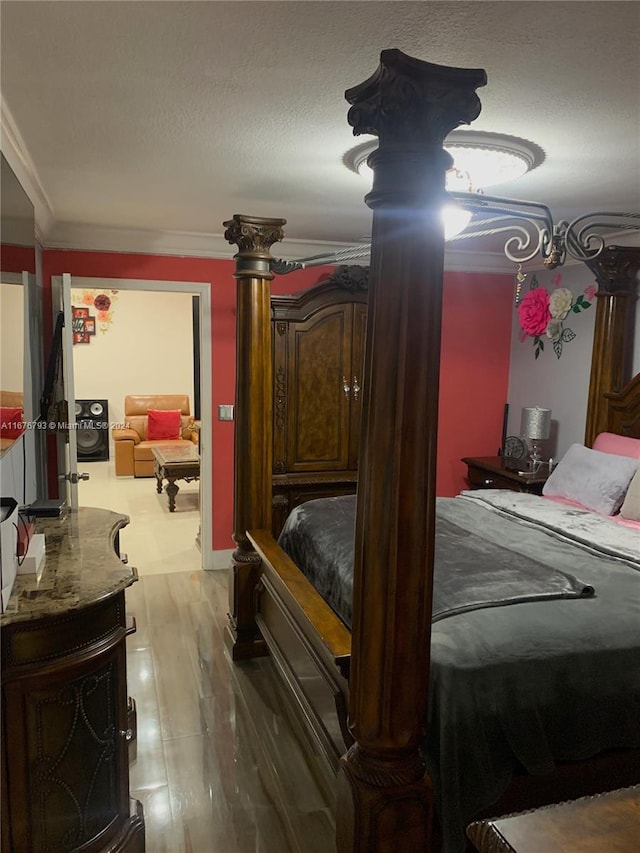 bedroom featuring hardwood / wood-style flooring, a textured ceiling, and ornamental molding