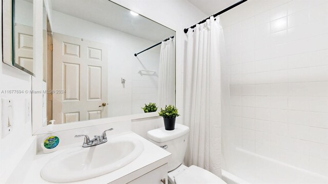 full bathroom with toilet, shower / bath combination with curtain, and vanity