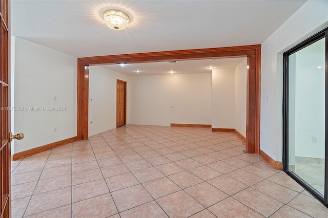 spare room featuring a textured ceiling and light tile patterned floors