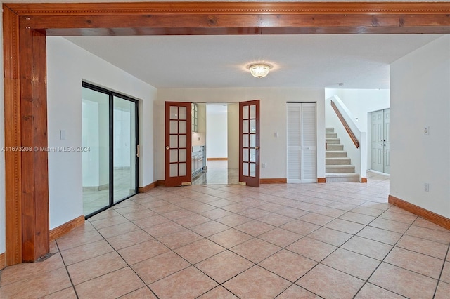 unfurnished room featuring french doors and light tile patterned floors