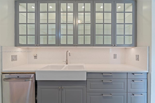 kitchen with sink, dishwasher, backsplash, gray cabinets, and light stone counters