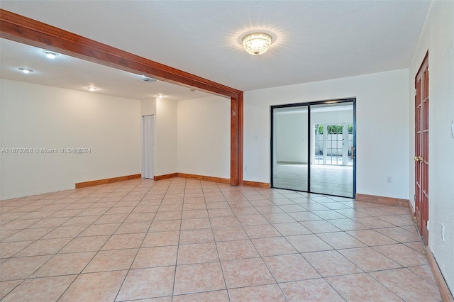 tiled spare room featuring a textured ceiling