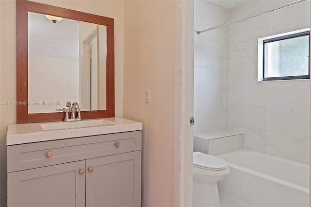 full bathroom with vanity, tiled shower / bath, and toilet