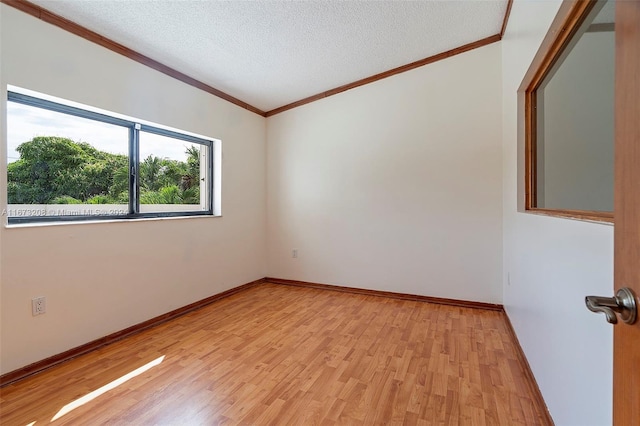 spare room with light hardwood / wood-style floors, crown molding, and a textured ceiling