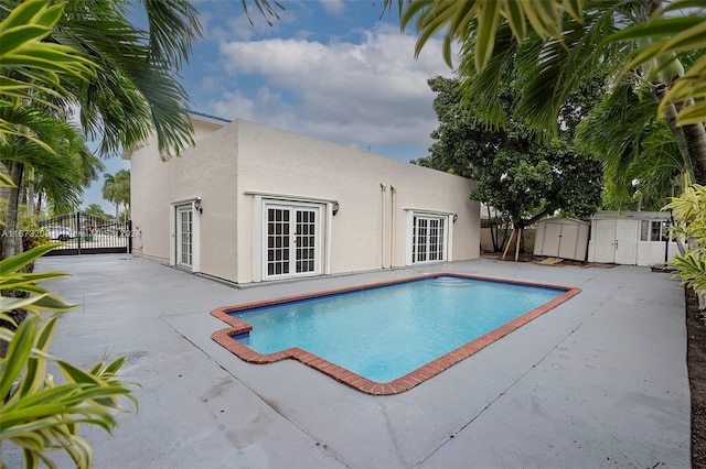 view of pool with a patio and a storage shed