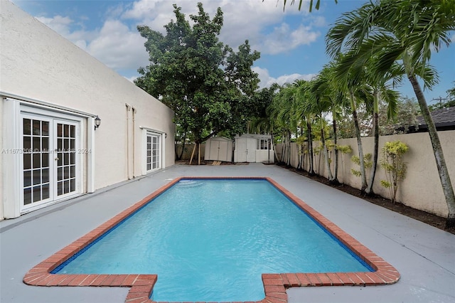 view of swimming pool featuring a patio and a shed