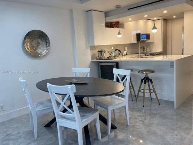 kitchen featuring decorative backsplash, kitchen peninsula, decorative light fixtures, and white cabinetry