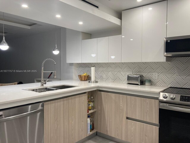 kitchen with stainless steel appliances, pendant lighting, decorative backsplash, light brown cabinetry, and white cabinets