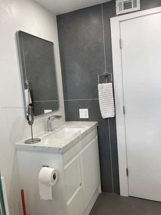 bathroom featuring vanity and tile walls