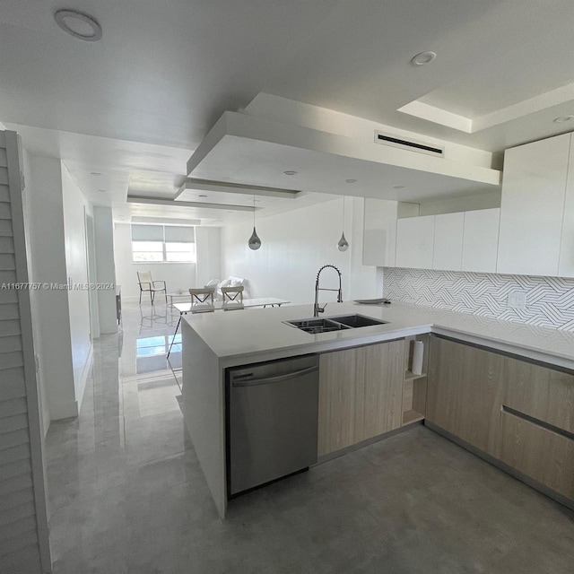 kitchen with kitchen peninsula, decorative backsplash, stainless steel dishwasher, and sink