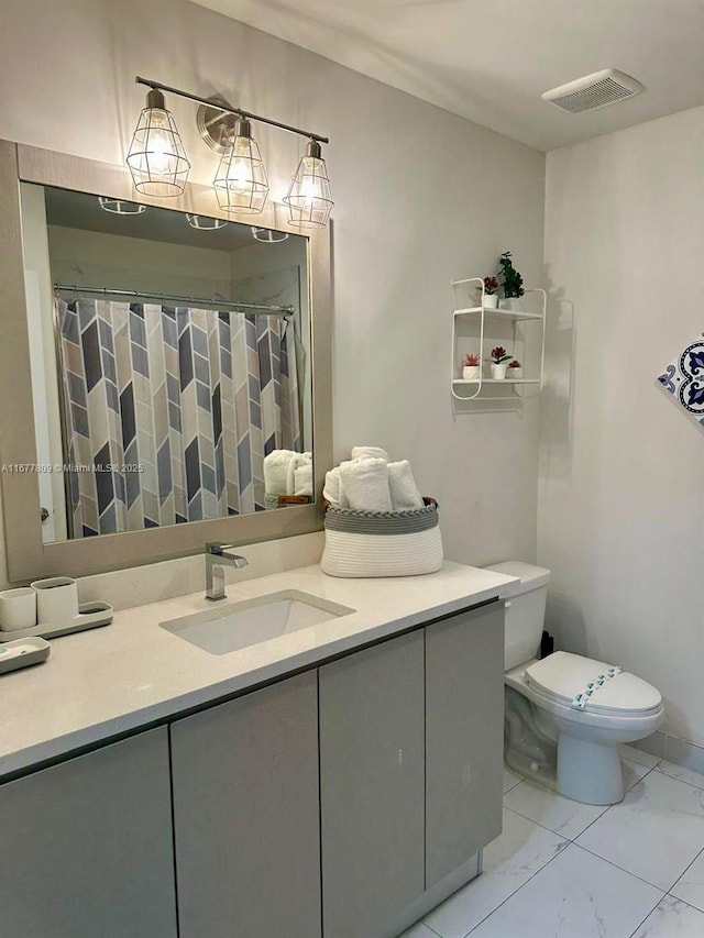 bathroom featuring toilet, vanity, and walk in shower