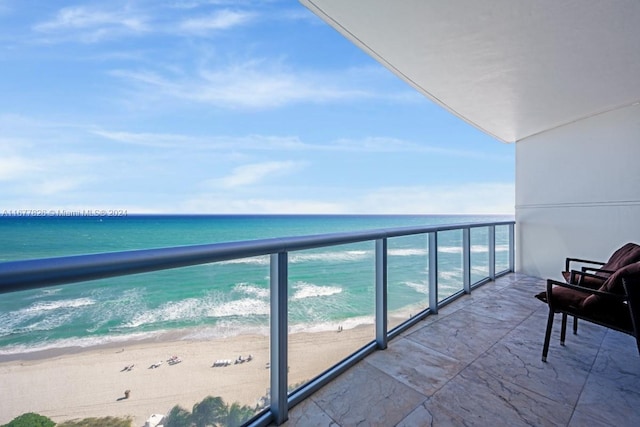 balcony with a water view and a beach view