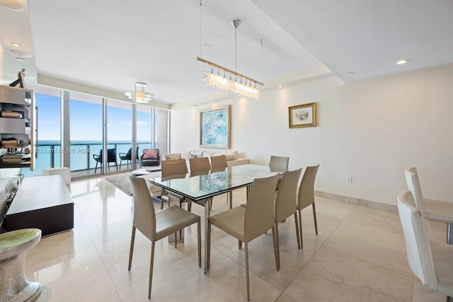 dining space with floor to ceiling windows and a water view