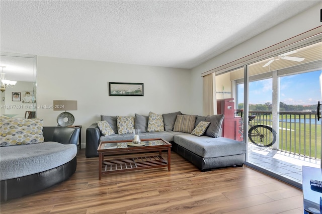 living room with ceiling fan, wood-type flooring, a textured ceiling, and plenty of natural light