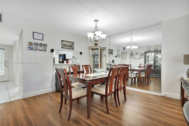 dining area with a chandelier, hardwood / wood-style flooring, and a textured ceiling