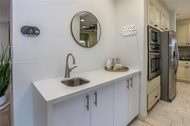 kitchen featuring light tile patterned floors, stainless steel appliances, sink, and cream cabinetry