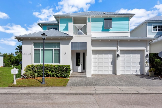 view of front of house with a front yard, a garage, and a balcony