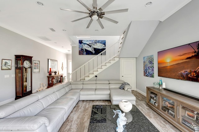 living room with ornamental molding, light hardwood / wood-style flooring, lofted ceiling, and ceiling fan