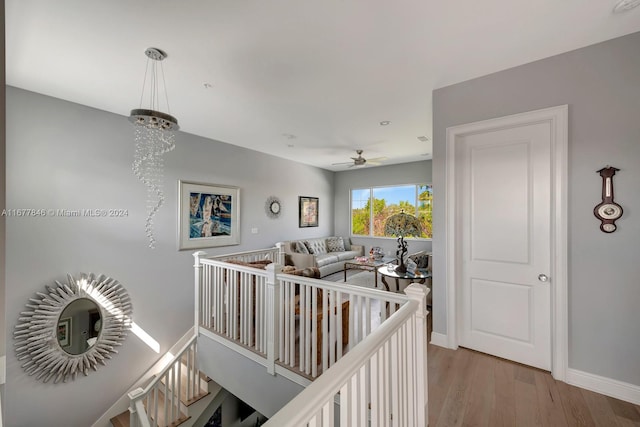 hallway featuring a notable chandelier and wood-type flooring