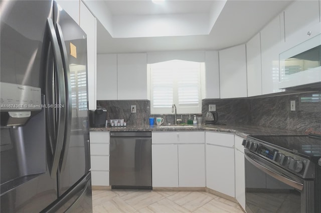 kitchen with black dishwasher, sink, white cabinets, stainless steel refrigerator, and range with electric stovetop