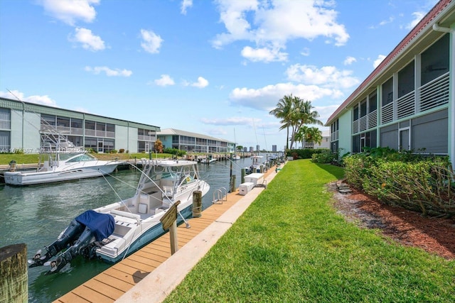 dock area with a lawn and a water view