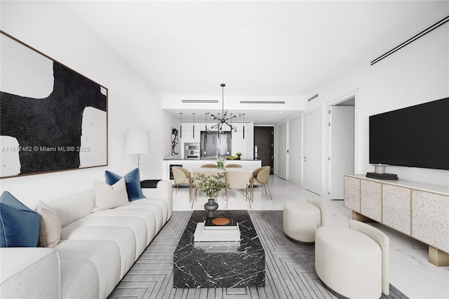 living room with marble finish floor and a chandelier